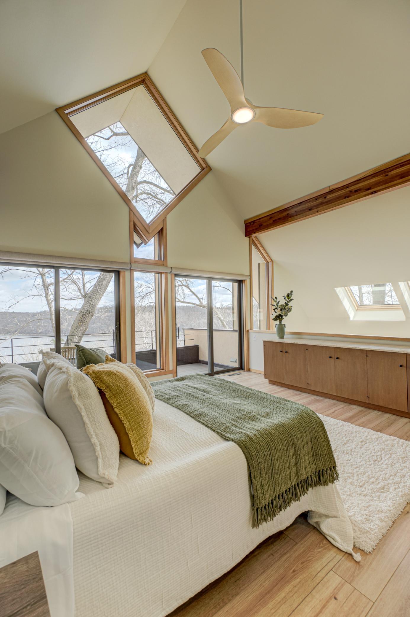 Sliding glass doors in the primary bedroom bring the serenty of the river indoors
