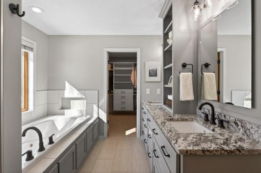 Jetted tub situated on a tile deck and surround with niche