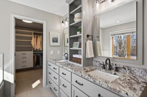 Enameled vanity with granite countertop, dual sinks, widespread faucets, and linen tower for added storage