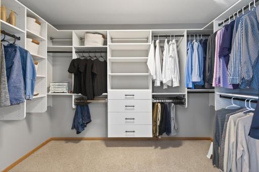 Generous walk-in closet in the ownerâs suite with custom organization systems