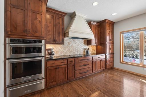 Suite of stainless steel KitchenAid appliances, dual wall ovens with warming drawer, induction cooktop, and dishwasher