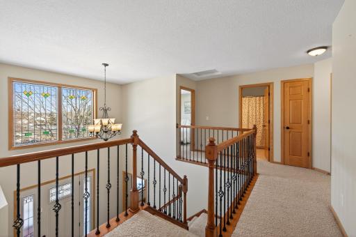 The grand open staircase with alder railings and iron balusters adds architectural interest and continuity