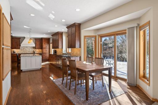 Informal dining area with full glass patio door leading to the deck, patios, and fenced backyard for seamless indoor-outdoor living