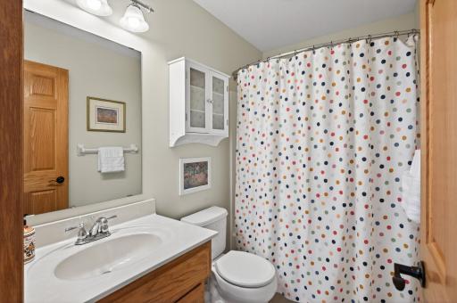 Upper-level full bath appointed with oak vanity cabinetry