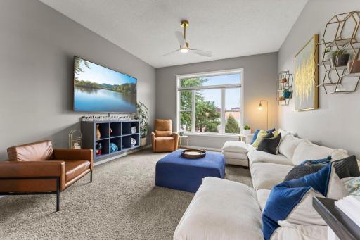 The living room feels bright and inviting with large windows overlooking the backyard.