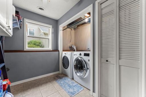 A dedicated laundry room with sink and cabinetry add everyday convenience.