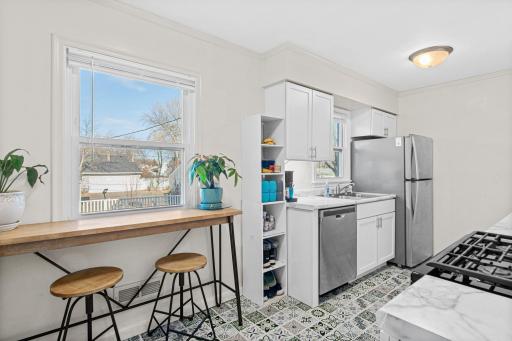 Recently updated kitchen with new cupboards, a tile floor, and stainless appliances