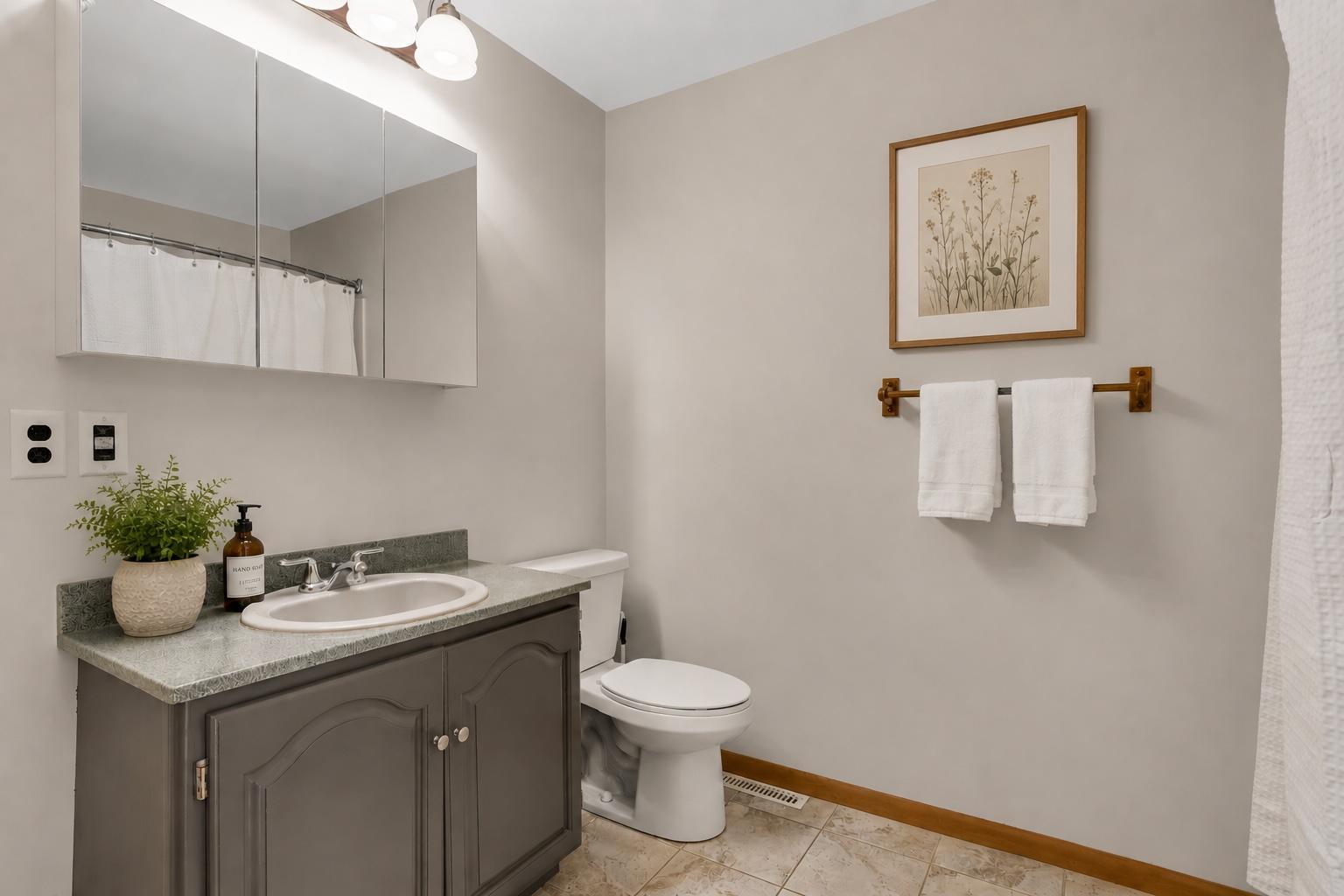 Upper level bedrooms share this generously sized bathroom with shower/tub combo as well as updated medicine cabinet, lighting, and vanity