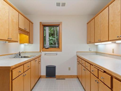 Abundant cabinetry, counter space, and a utility sink create a versatile support space for entertaining, hobbies, and lake-life organization.