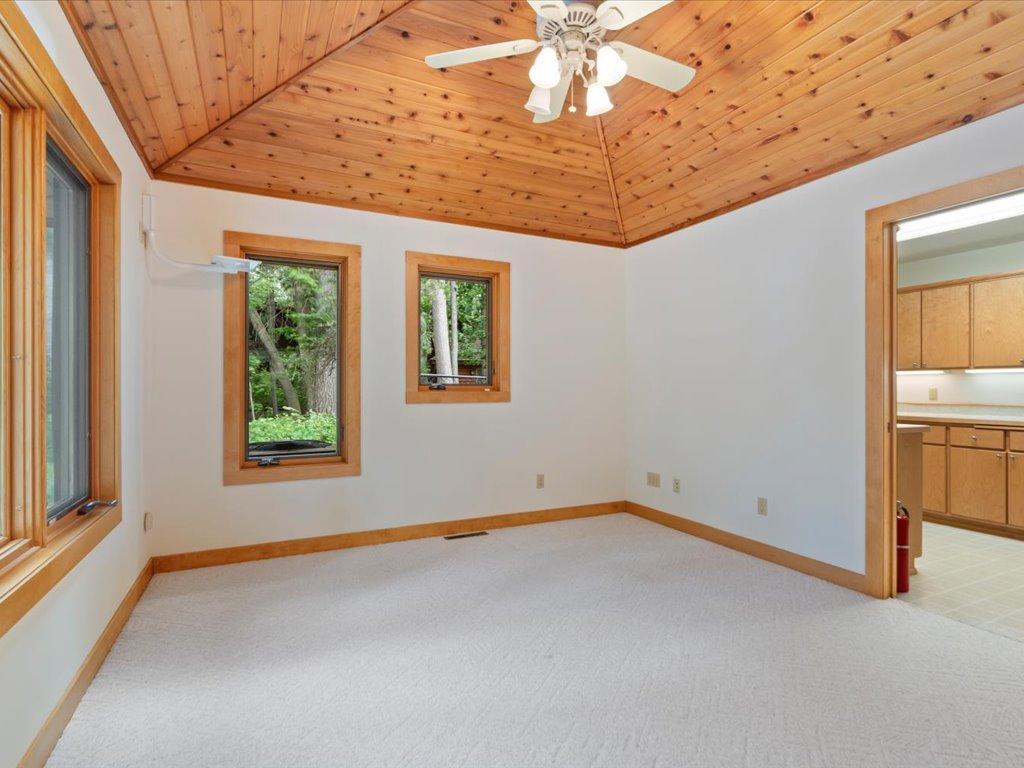 Vaulted wood ceilings and peaceful woodland views create a welcoming retreat on the main level.