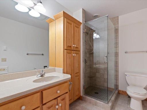 A well-appointed upper-level bath features a tiled walk-in shower and convenient access to the home's guest accommodations.