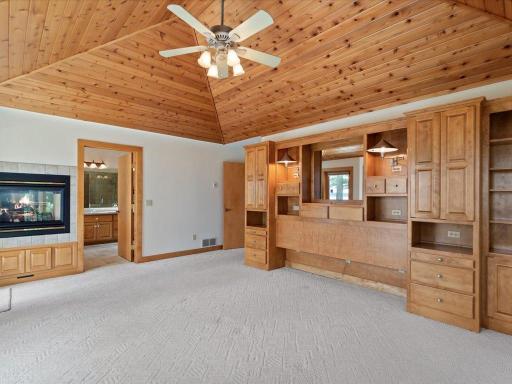 Generous proportions, vaulted knotty pine ceilings, and a cozy fireplace create a private retreat within the main-level primary suite.