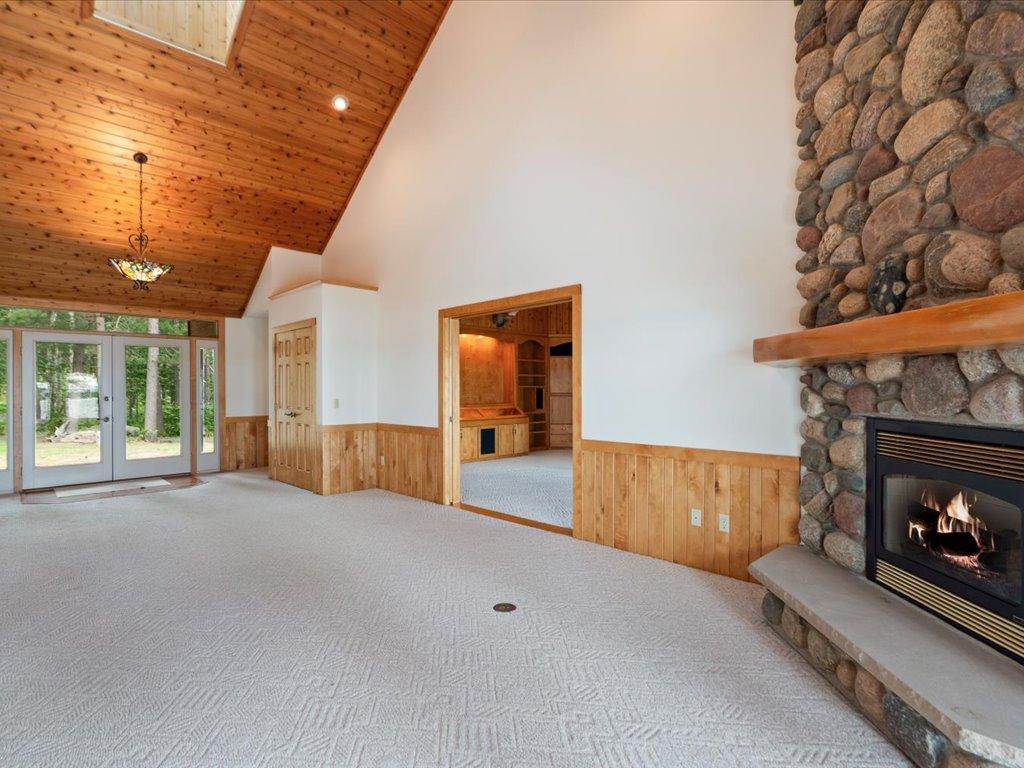 Soaring ceilings, a dramatic stone fireplace, and seamless flow between the living and family rooms create an inviting space for gathering and entertaining.