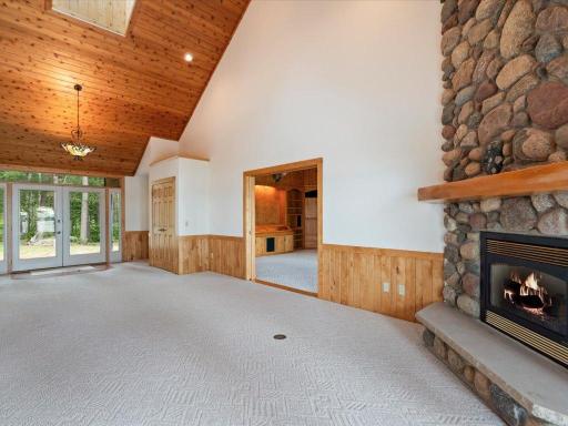 Soaring ceilings, a dramatic stone fireplace, and seamless flow between the living and family rooms create an inviting space for gathering and entertaining.