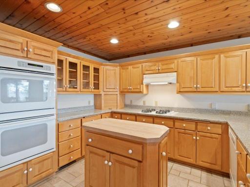 Abundant cabinetry, extensive counter space, and a center island create a kitchen designed to accommodate everything from intimate meals to large family gatherings.