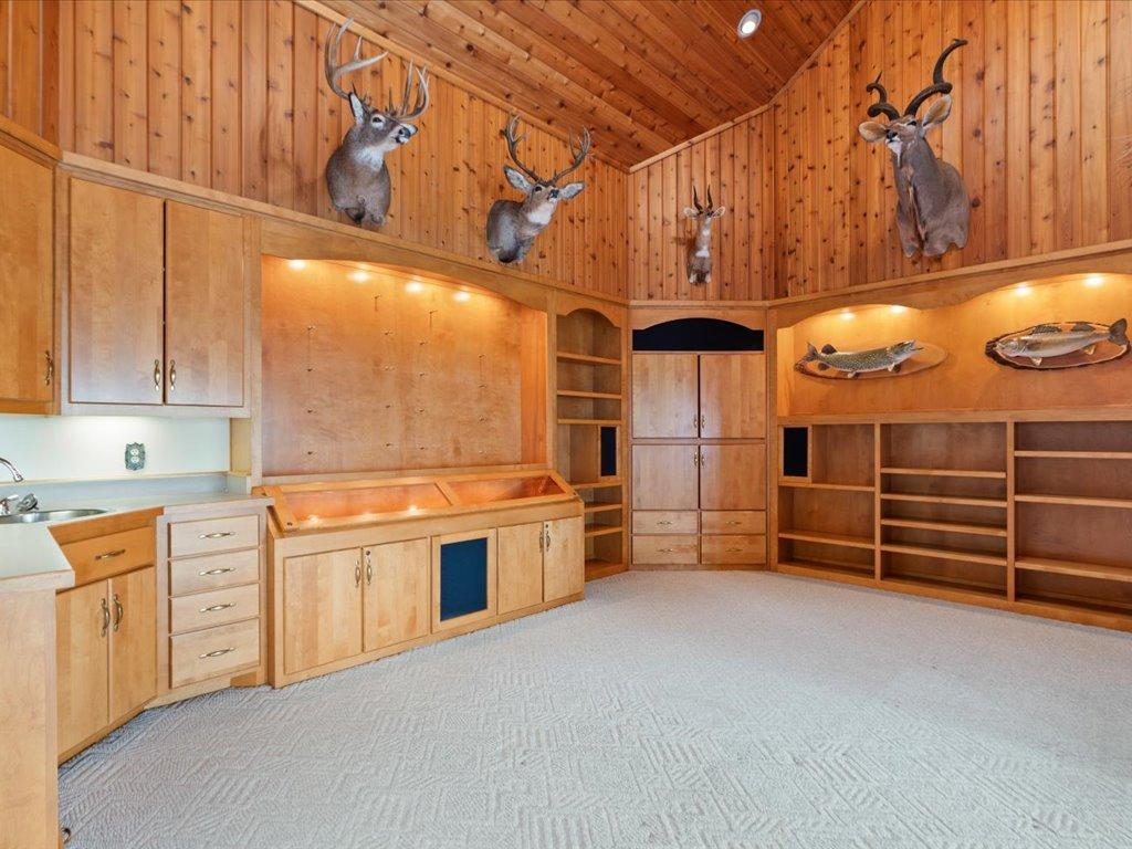 Custom built-ins, a locking display cabinet, and wet bar amenities create a versatile space for entertaining, collections, and recreation.