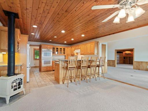 A freestanding gas stove adds warmth and ambiance to the open dining and kitchen areas, creating an inviting space for gathering.