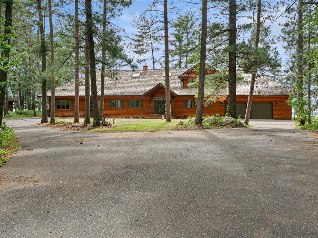 A winding drive through towering pines leads to this private Northwoods estate, where timeless architecture and exceptional acreage create a memorable first impression.