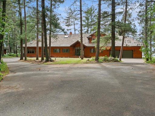 A winding drive through towering pines leads to this private Northwoods estate, where timeless architecture and exceptional acreage create a memorable first impression.