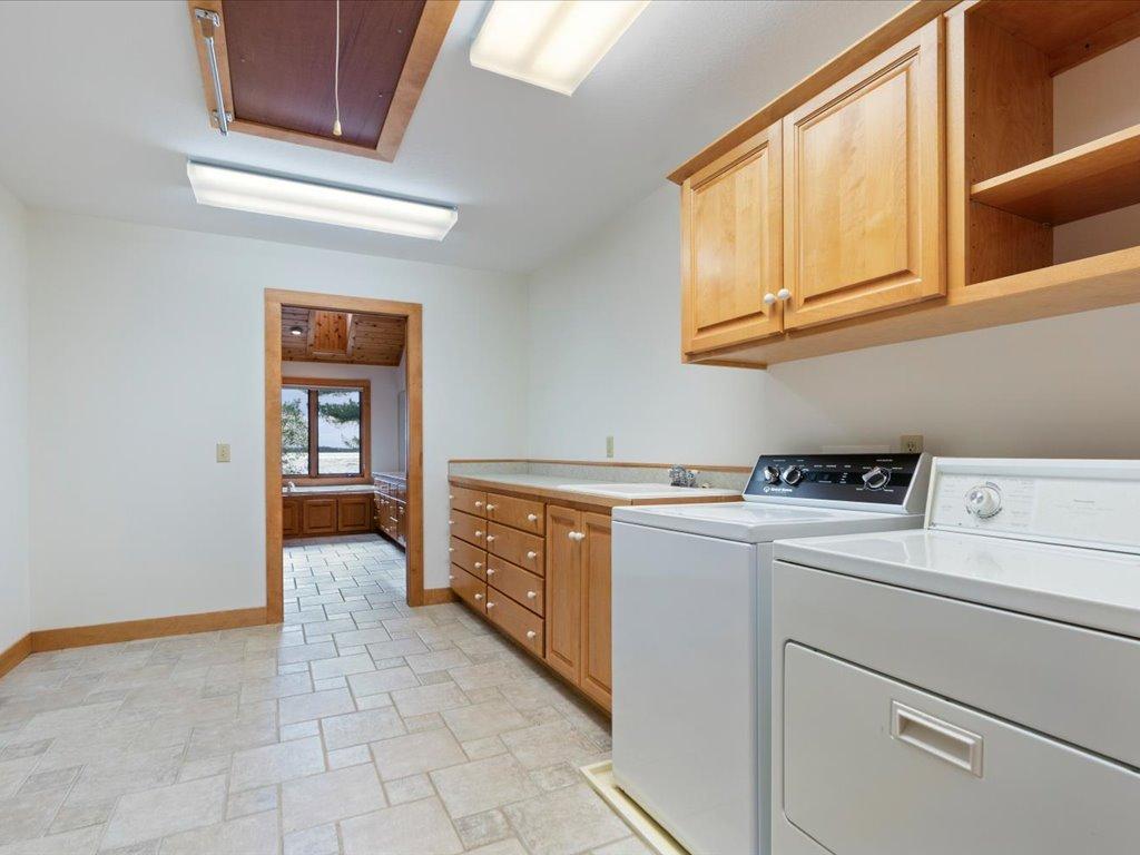 The spacious laundry room offers abundant cabinetry, extensive counter space, and exceptional storage for everyday convenience.