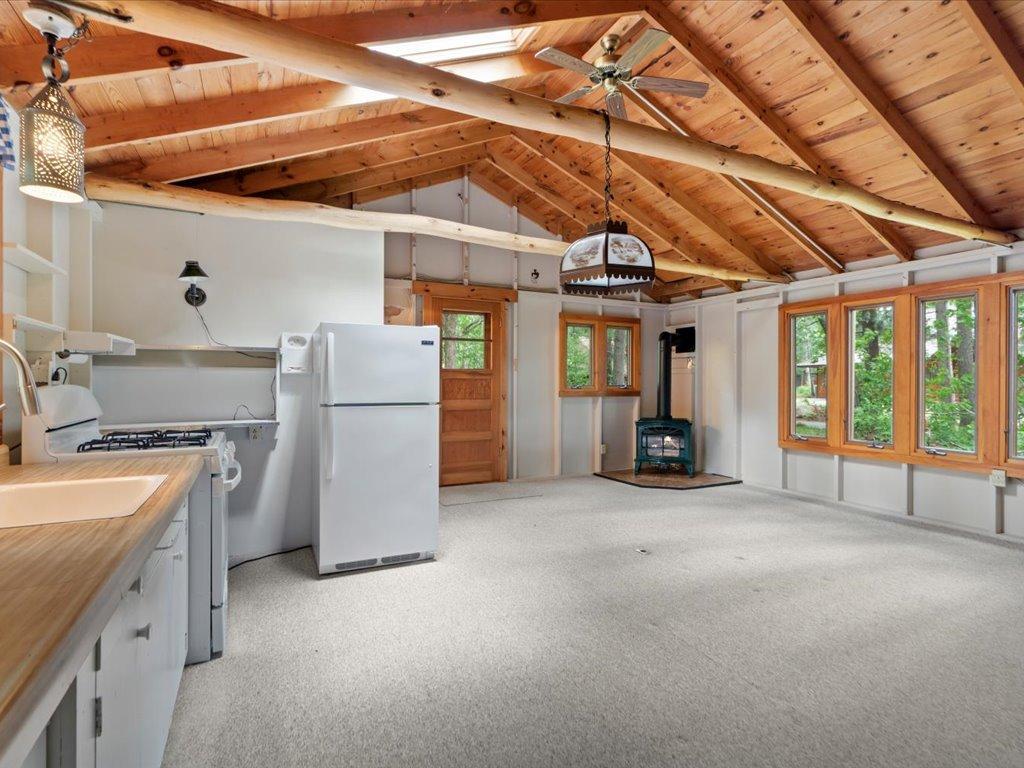 The guest cabin offers a welcoming gathering space complete with a kitchenette, gas stove, and warm Northwoods character.
