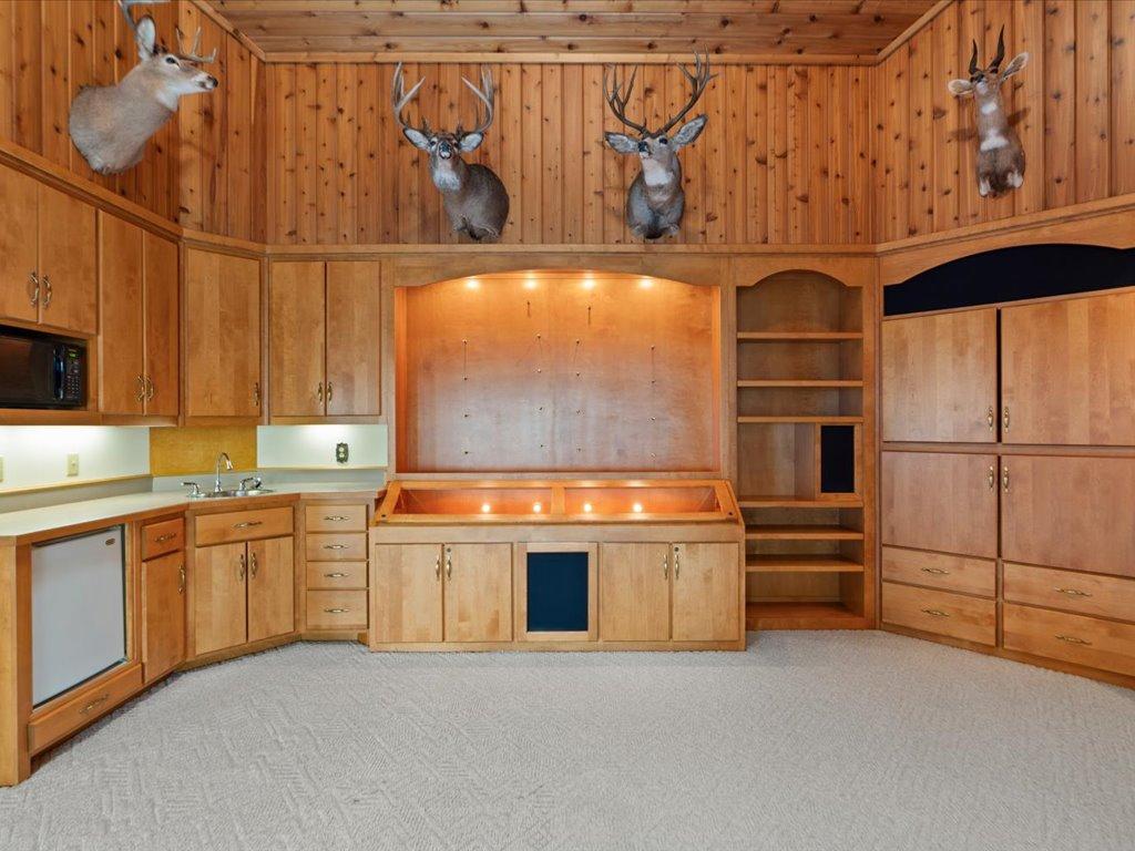 The family room features custom built-ins, a wet bar, display cabinetry, and distinctive Northwoods character, creating an ideal space for entertaining and showcasing treasured collections.