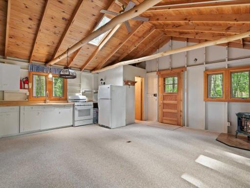 Exposed log beams, vaulted ceilings, and an open-concept layout create a welcoming retreat within the guest cabin.
