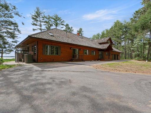 A paved circular drive connects the attached two-car garage and detached three-stall garage, creating a seamless arrival experience and exceptional functionality throughout the estate.