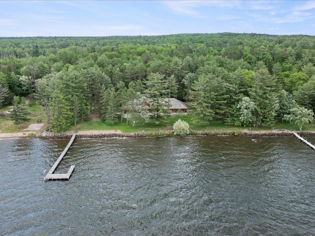 Nestled among towering pines on a private lakeside setting, the property offers exceptional privacy, expansive grounds, and 300 feet of shoreline.