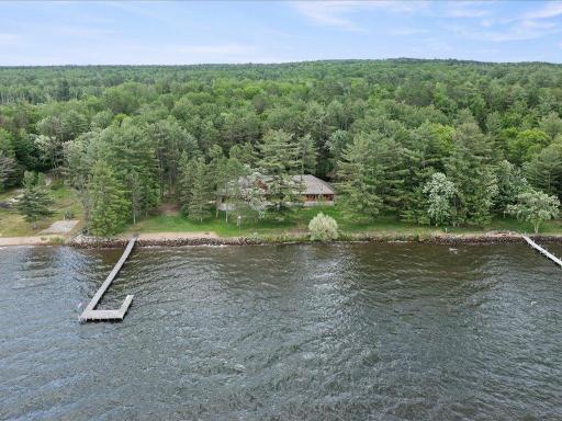 Nestled among towering pines on a private lakeside setting, the property offers exceptional privacy, expansive grounds, and 300 feet of shoreline.