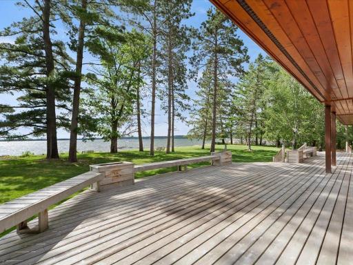 Designed for effortless outdoor living, the expansive deck overlooks the level lawn, mature pines, and sparkling waters of Upper Whitefish Lake.