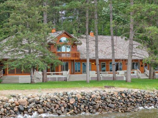 Classic Northwoods architecture, expansive lakeside decking, and towering pines create a timeless waterfront retreat.