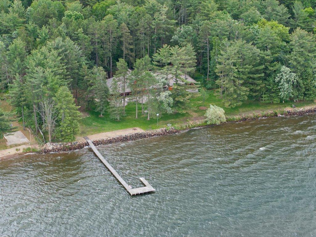 From the water, the estate's private shoreline, dock, and wooded setting showcase the rare privacy and natural beauty of Upper Whitefish Lake.