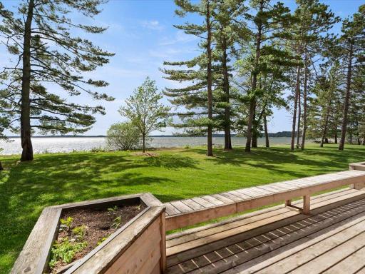 Mature pines, a manicured lakeside lawn, and sweeping water views create a timeless Northwoods setting.