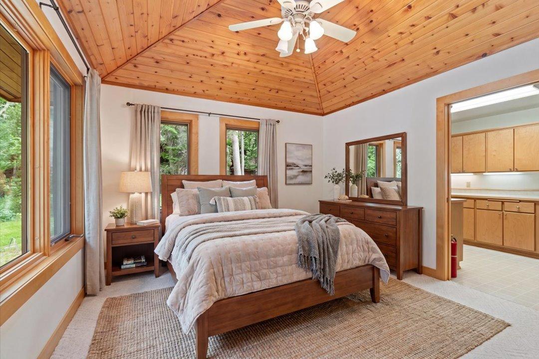 Virtually Staged. Vaulted wood ceilings and peaceful woodland views create a welcoming retreat on the main level.