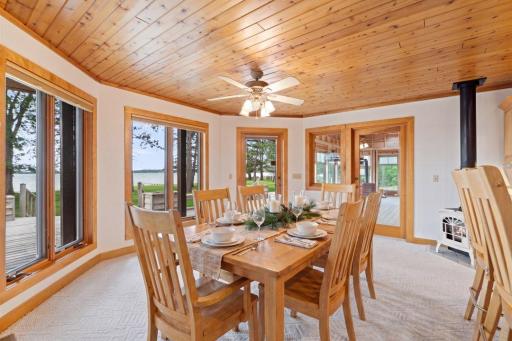 Virtually Staged. The dining area enjoys beautiful lake views and seamless access to both the lakeside deck and vaulted three-season porch.