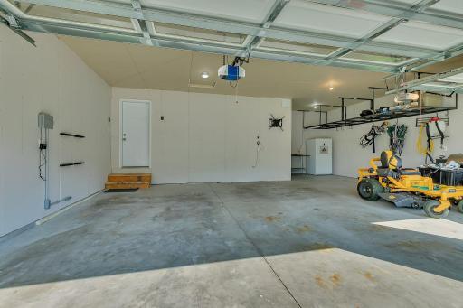 The 3 car garage features a deep bump out in the back that is perfect for storage or a work shop space! The hanging shelving stays with the home. Both of the garage doors have access to myQ smart home garage door.