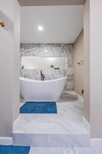 Luxurious soaking tub on raised platform in lower level 2nd primary suite!