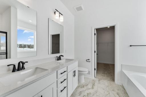 Designed for utmost versatility, the en-suite bathroom features a glass-enclosed shower for daily cleaning rituals and a corner tub perfect for indulgent soaks