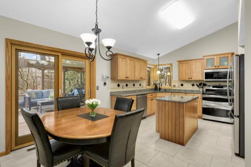 Remodeled kitchen includes updated maple cabinets complete with built-in cabinet storage organizers, granite countertops, center island & convenient in kitchen dining option that opens to family room.