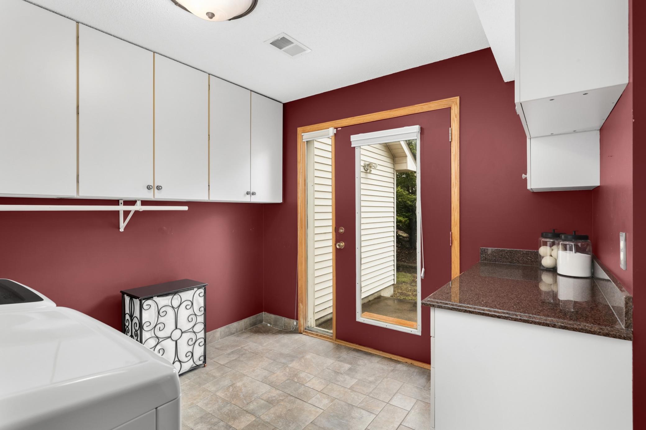 Large Laundry Room on the main level next to the garage entry/mudroom. This space has extensive storage, folding counter space and access to the east side of the yard.