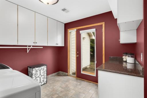 Large Laundry Room on the main level next to the garage entry/mudroom. This space has extensive storage, folding counter space and access to the east side of the yard.