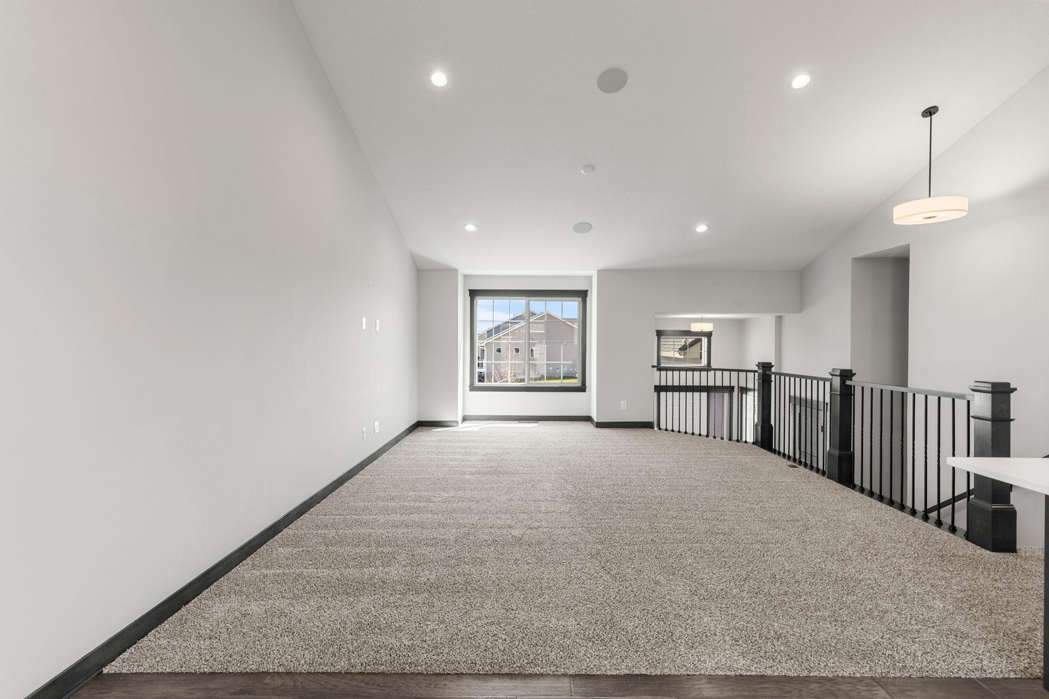 Open floor plan with vaulted ceilings. Warm, neutral colors throughout. Vaulted ceilings and built-in speakers on main level.