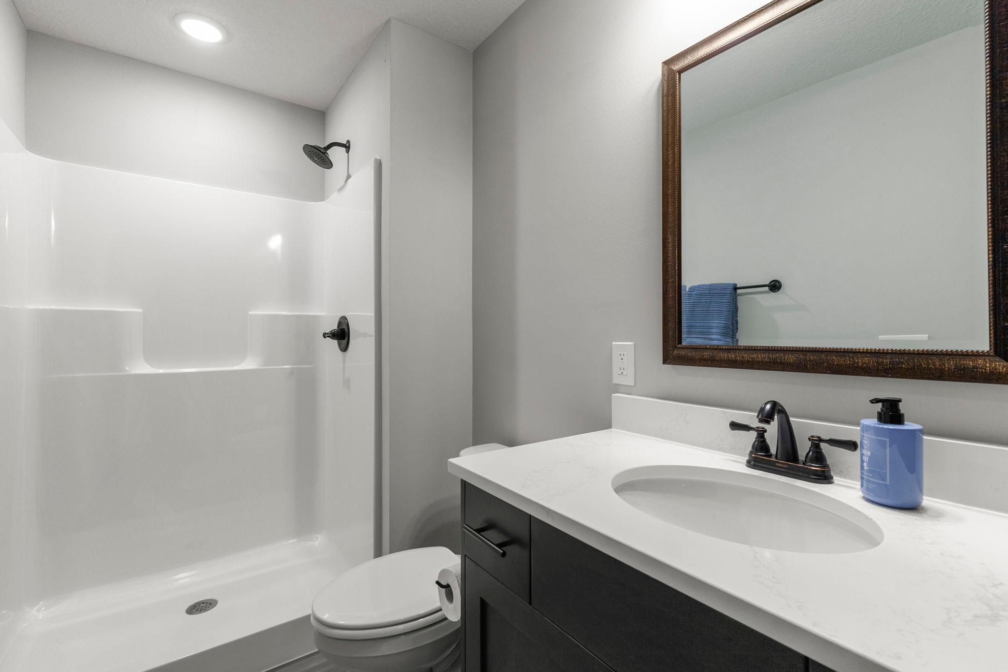 3/4 basement bathroom with upgraded tiled flooring. Shows just like new!