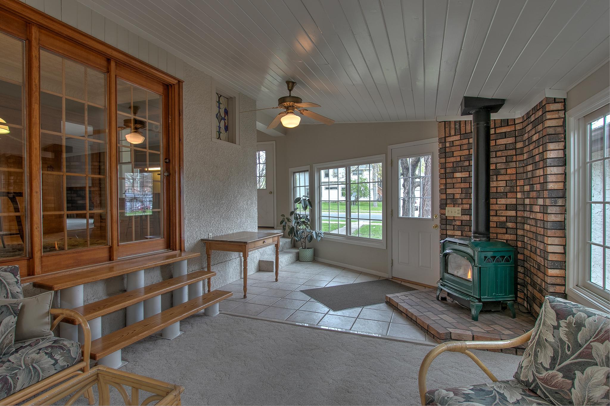 Warm and inviting Sun Room with abundant natural light and a cozy gas fireplace.