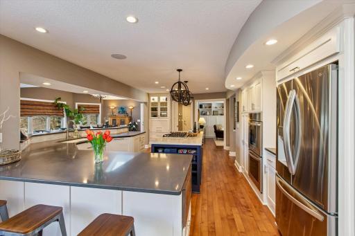 Enormous center island with gas stove top looking back towards den & living room