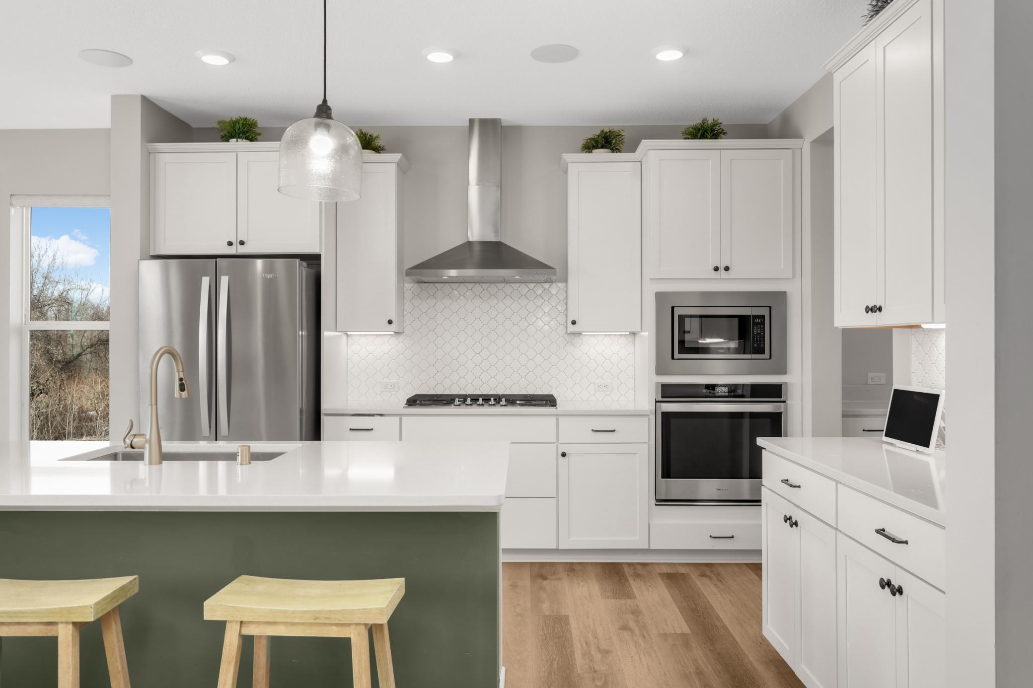 Stainless steel appliances, double oven, gas range w/hood and classic white cabinetry. Note the wired overhead speakers, a nice upgrade.