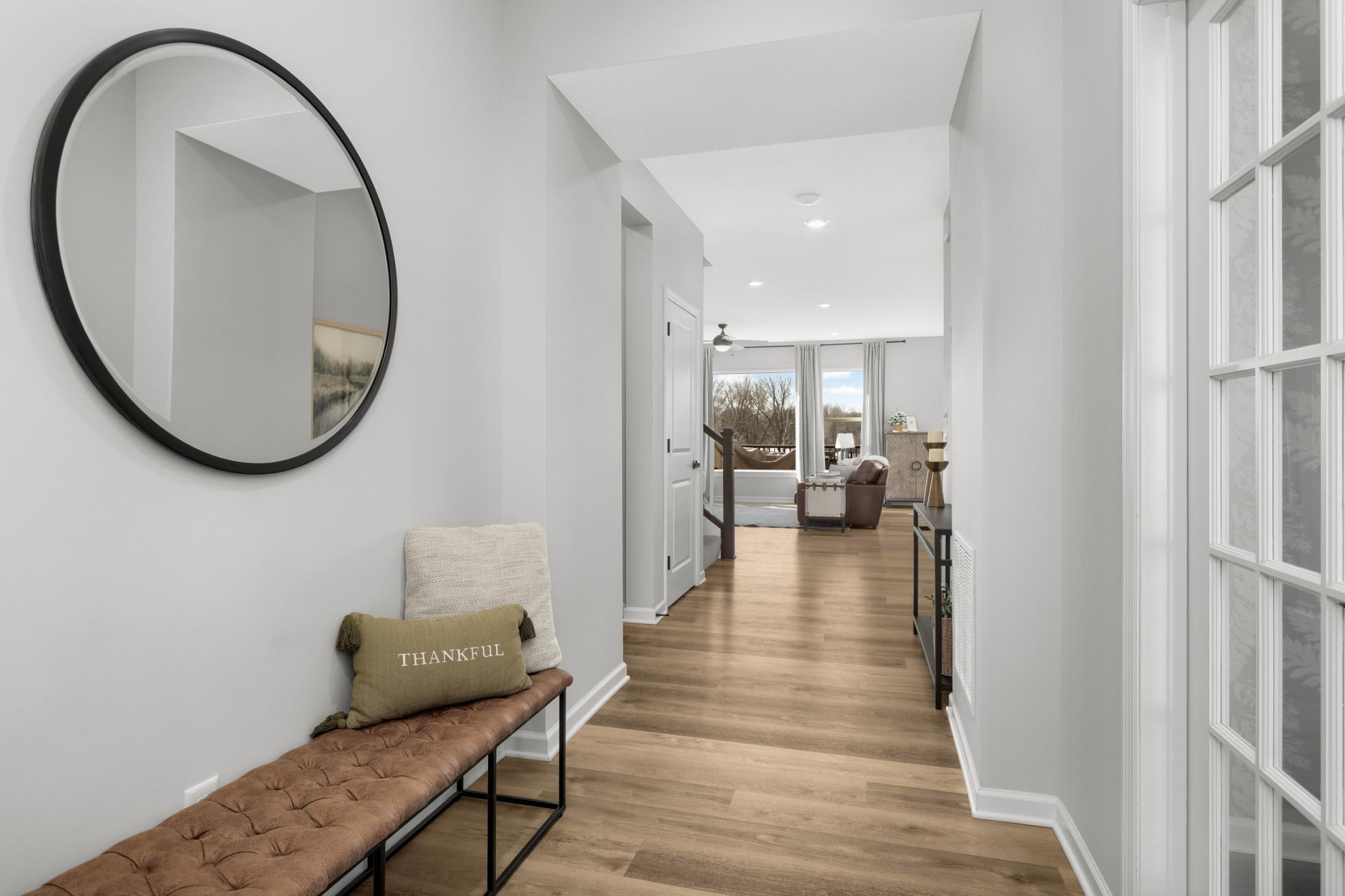 Welcoming foyer with neutral paint wide hallway into the main living spaces.
