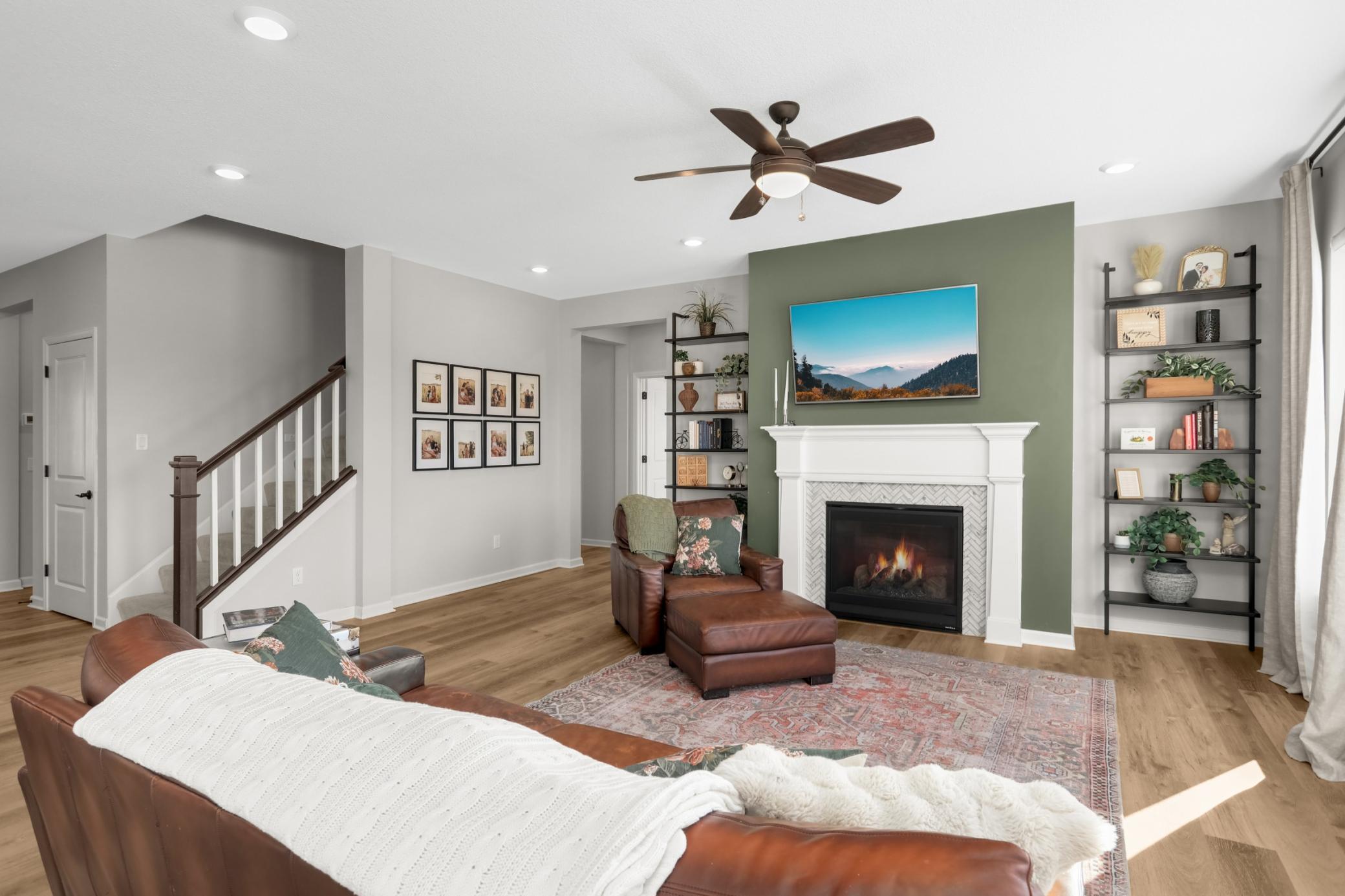 Cozy gas fireplace and view to the stairwell going upstairs.
