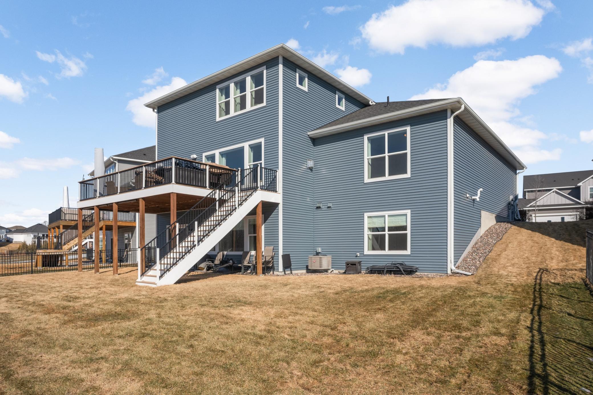 Back of the home featuring the deck and flat yard. Note the home also had gutters added, a nice added feature.